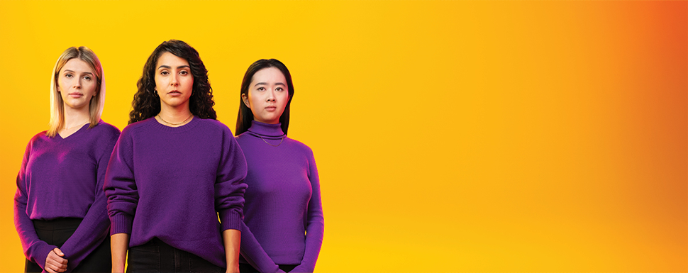 Image of 3 young women (one Caucasian, one Latina and one Asian) wearing purple shirts and black pants on a yellow background